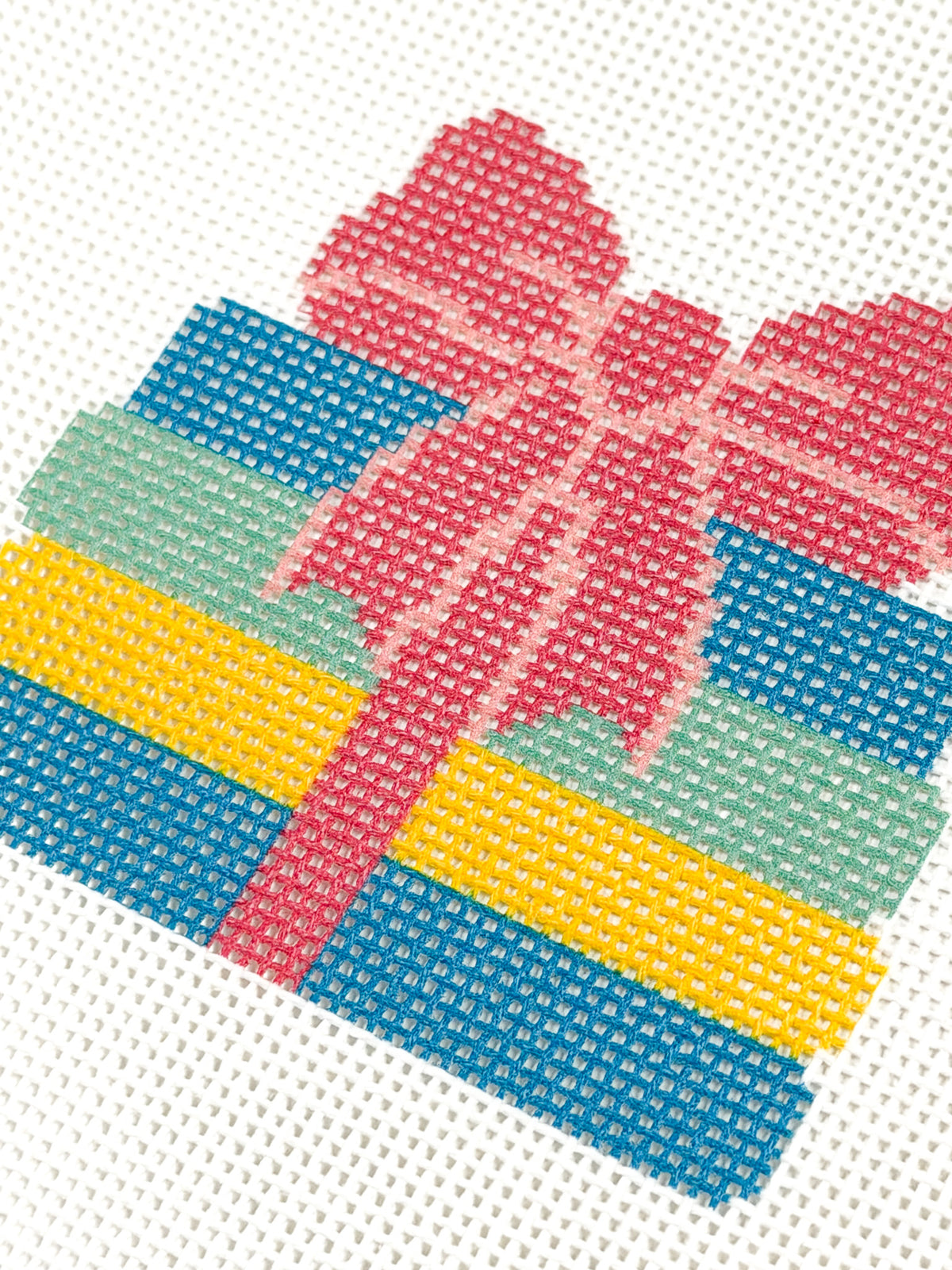 Close-up of the pink bow and colorful book stack on Books with a Bow needlepoint canvas.