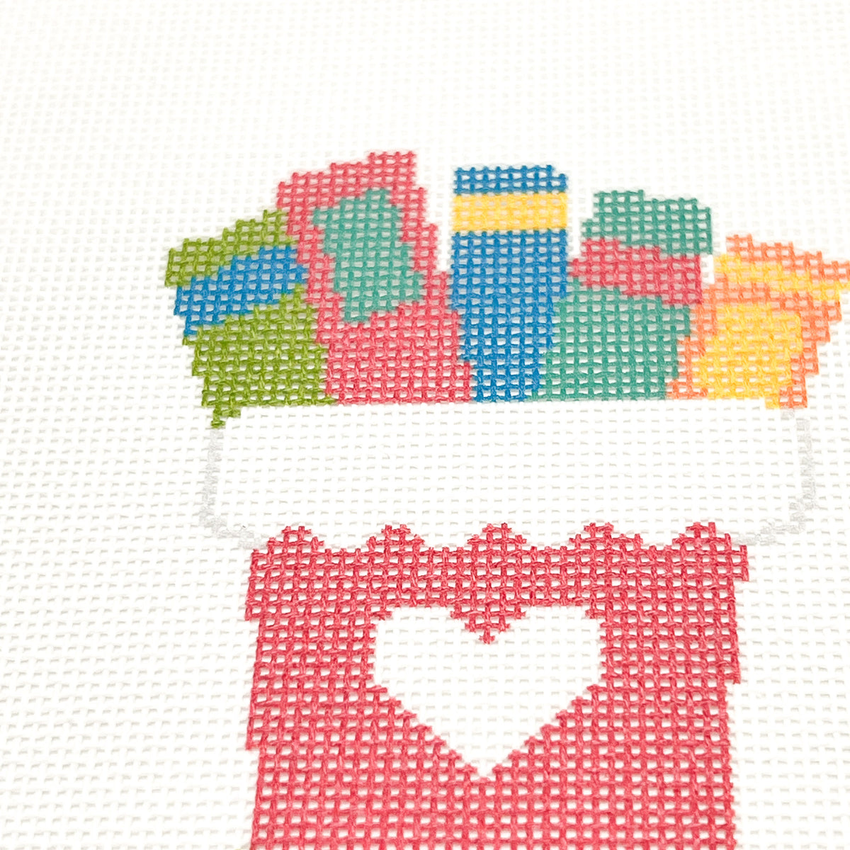 Close-up of colorful books on the Rainbow Books Christmas Stocking needlepoint canvas