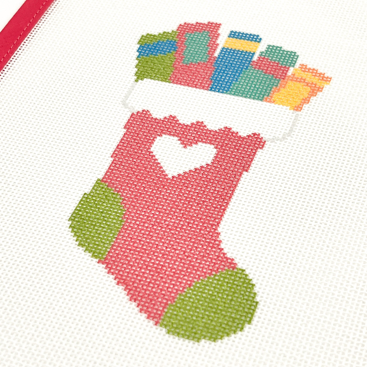Close-up of Rainbow Books Christmas Stocking needlepoint canvas with pink stocking and green heel and toe